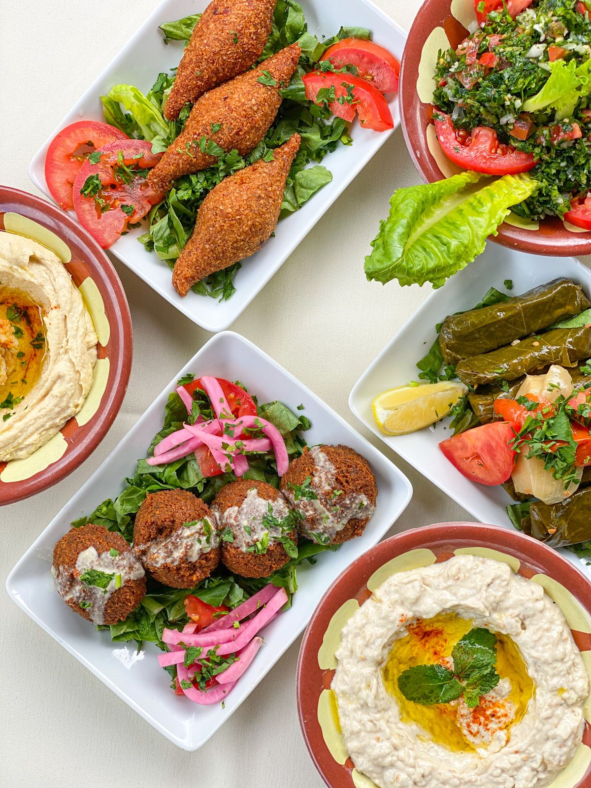 A shared table of Mediterranean plates at Layal Cafe